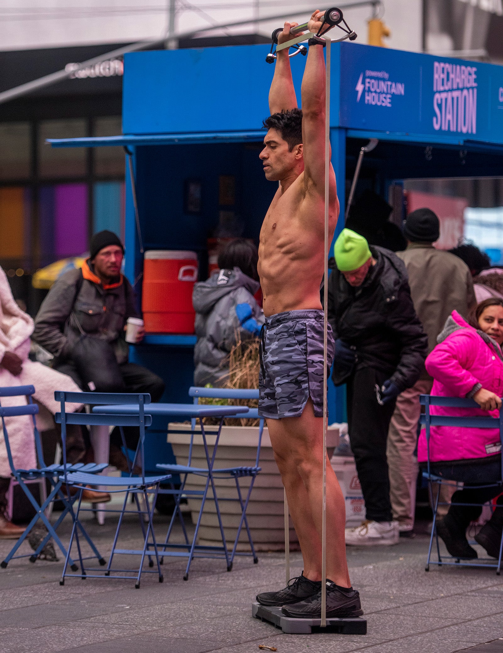 Picture of Khalid doing overhead press with the K Bundle in public.